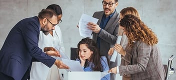 Manager surrounded by 5 coworkers demanding attention