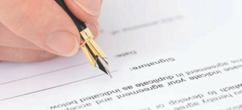 Closeup of hand signing an agreement document