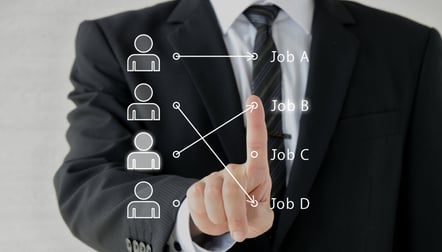 Businessman matching team members to jobs on digital diagram_2000x1143