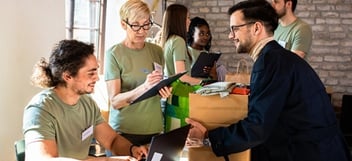 Dropping off a box of home goods at a vibrant donation center