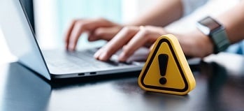Someone working on laptop with yellow 