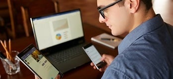 A CPA checking three devices at the same time: smartphone, tablet, and laptop
