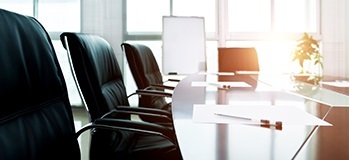 Corporate board table with a few open seats