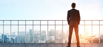 CPA on a balcony looking over a wide business landscape